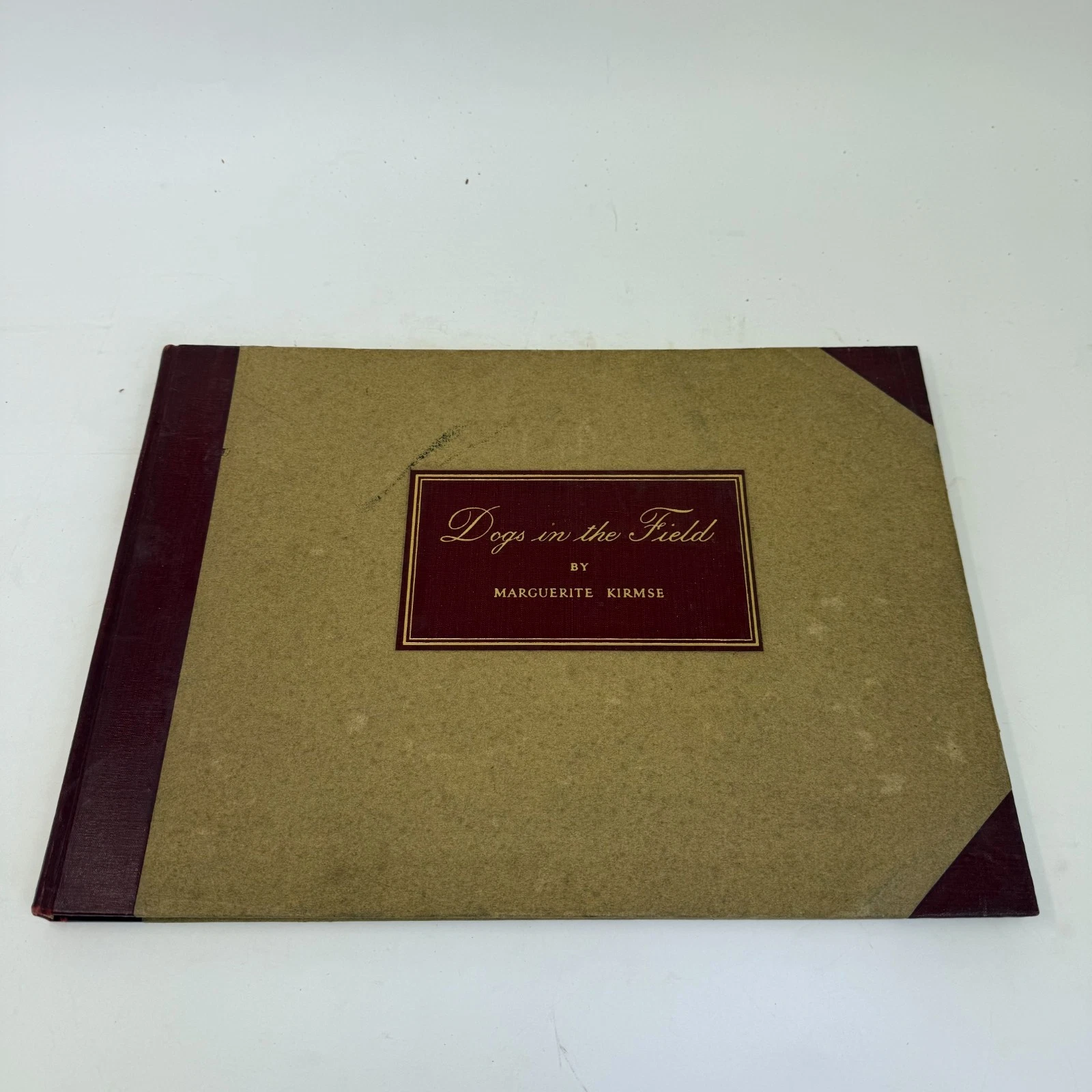 Cover of Dogs in the Field by Marguerite Kirmse, tan cloth with red leather title label