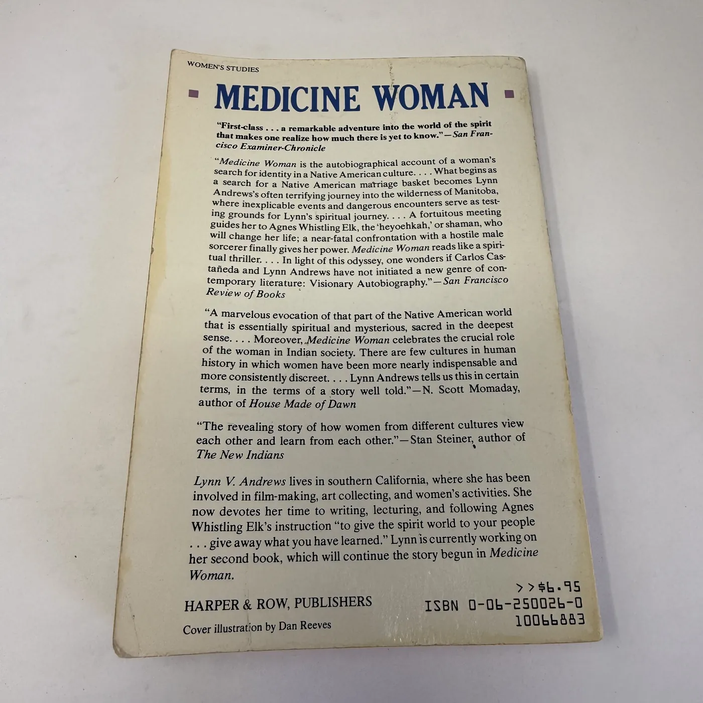 The back cover of the 1983 Harper & Row paperback of Medicine Woman, with a 'WOMEN'S STUDIES' header at the top left, the title MEDICINE WOMAN in large display capitals across the top, and below it a stack of pull-quote blurbs from reviews: the San Francisco Examiner-Chronicle review, a long block summarizing the narrative ('Medicine Woman is the autobiographical account of a woman's search for identity in a Native American culture'), the San Francisco Review of Books quote comparing Andrews to Carlos Castaneda and proposing they have initiated 'a new genre of contemporary literature: Visionary Autobiography', the N. Scott Momaday blurb identifying him as 'author of House Made of Dawn', and the Stan Steiner blurb identifying him as 'author of The New Indians'. An italicized author-bio paragraph below describes Lynn V. Andrews as living in southern California, involved in film-making, art collecting, and women's activities, devoting time to 'writing, lecturing, and following Agnes Whistling Elk's instruction'. The publisher line at lower left reads HARPER & ROW, PUBLISHERS, Cover illustration by Dan Reeves. The retail price modest value, ISBN 0-06-250026-0, and shelving barcode 10066883 are at the lower right.