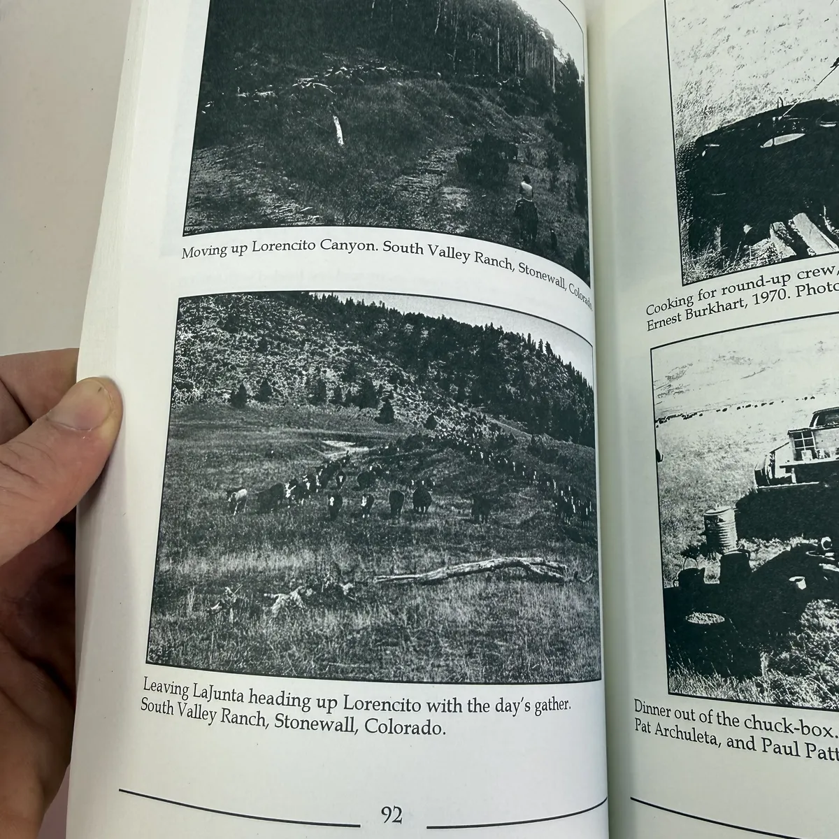 Interior page from the Diamond A Cattle Company chapter showing 1970s photographs of cattle drives at Lorencito Canyon and South Valley Ranch in Stonewall, Colorado, including Pat Archuleta and Paul Patterson at a chuck box with Ernest Burkhart in the photo credits