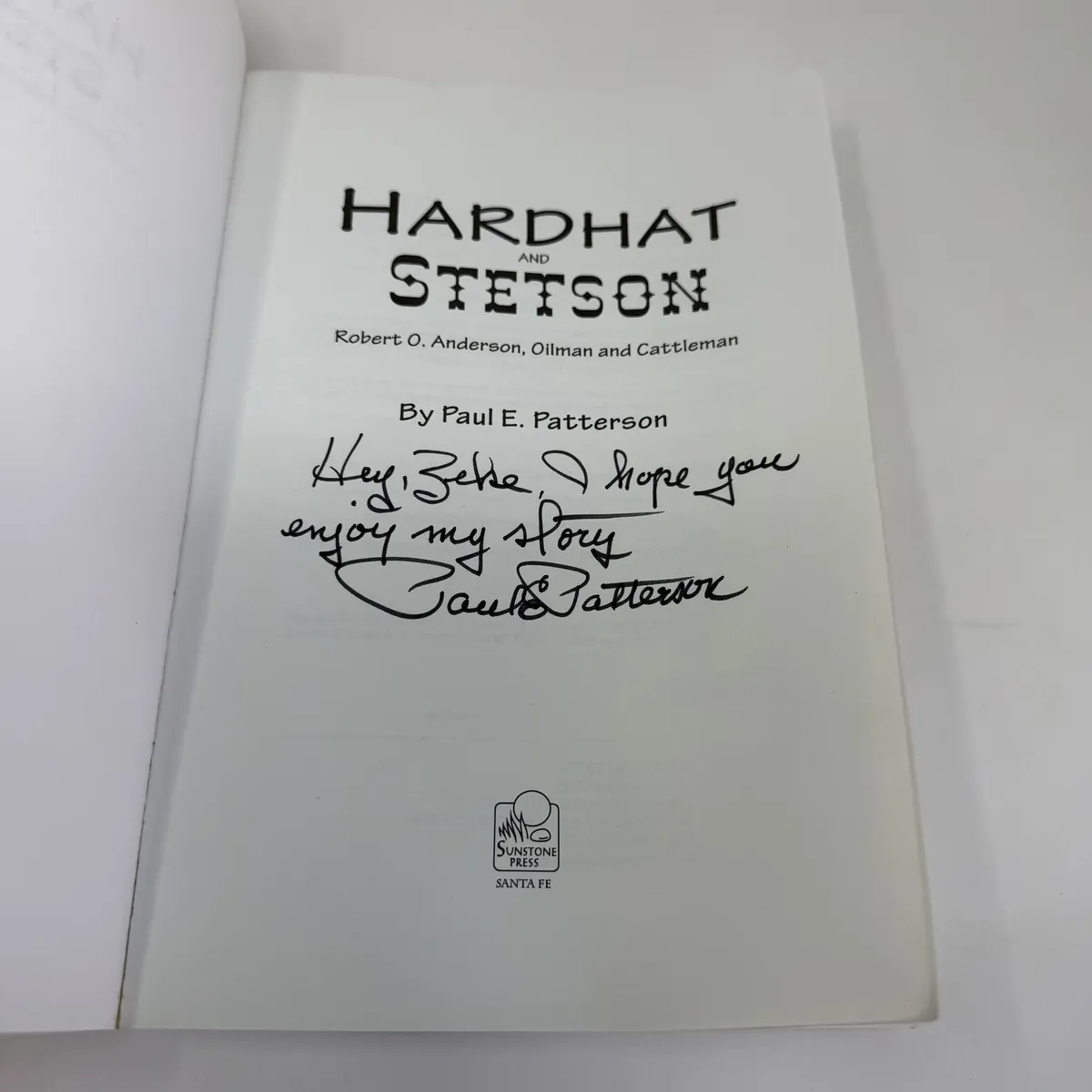 Title page of Hardhat and Stetson with the inscription 'Hey, Zeke, I hope you enjoy my story' and the signature of Paul E. Patterson in dark ink, with the Sunstone Press logo and Santa Fe imprint below