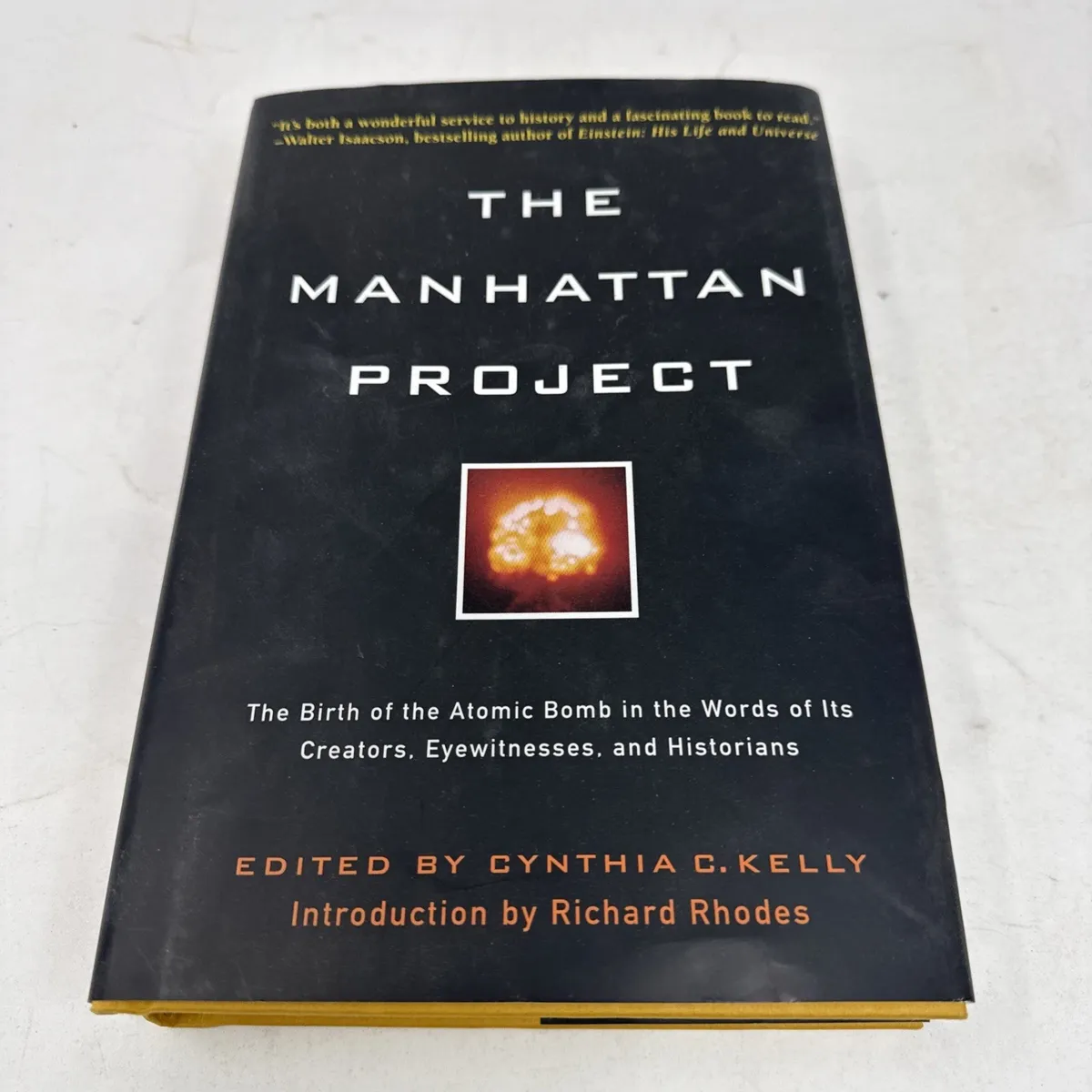 Hardcover dust jacket of The Manhattan Project, black with white serif typography of the title and a small inset color photograph of an atomic-bomb mushroom cloud. Subtitle: The Birth of the Atomic Bomb in the Words of Its Creators, Eyewitnesses, and Historians. Edited by Cynthia C. Kelly. Introduction by Richard Rhodes.