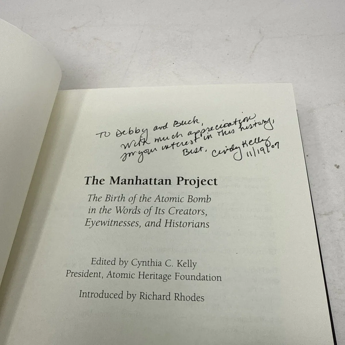 The title page of The Manhattan Project with a personalized inscription in cursive ink at the top: To Debby and Buck, With much appreciation, for your interest in this history. Best, Cindy Kelly 11/19. Below the inscription is the printed title block.
