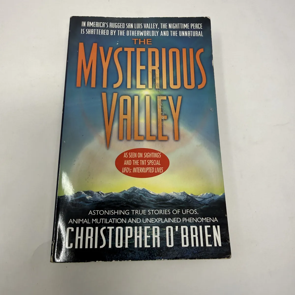 Mass-market paperback cover of The Mysterious Valley by Christopher O'Brien St. Martin's 1996 first edition UFO/cattle-mutilation San Luis Valley