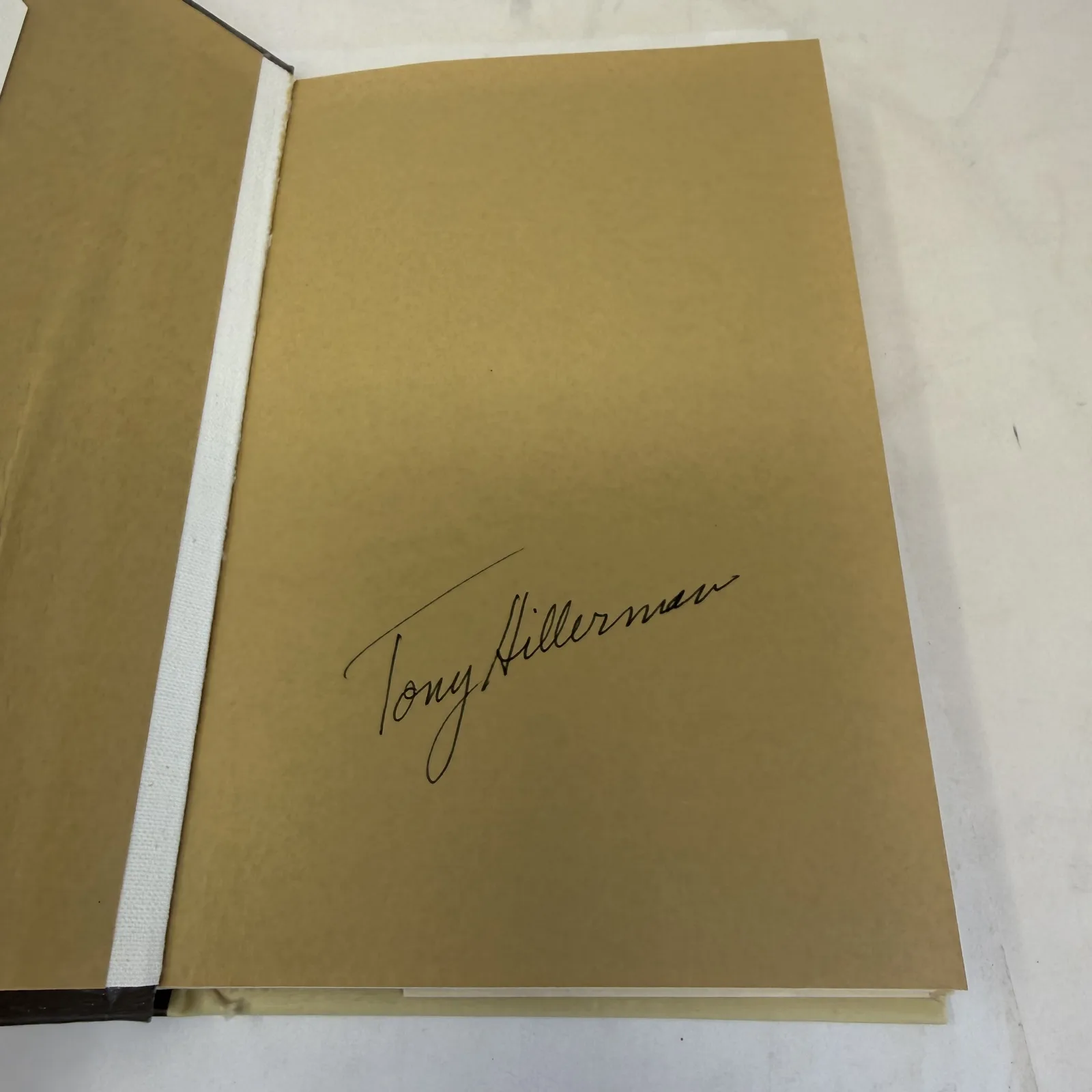 Tony Hillerman ink signature on the gold endpaper of a stated first edition of The Boy Who Made Dragonfly, photographed at New Mexico Literacy Project