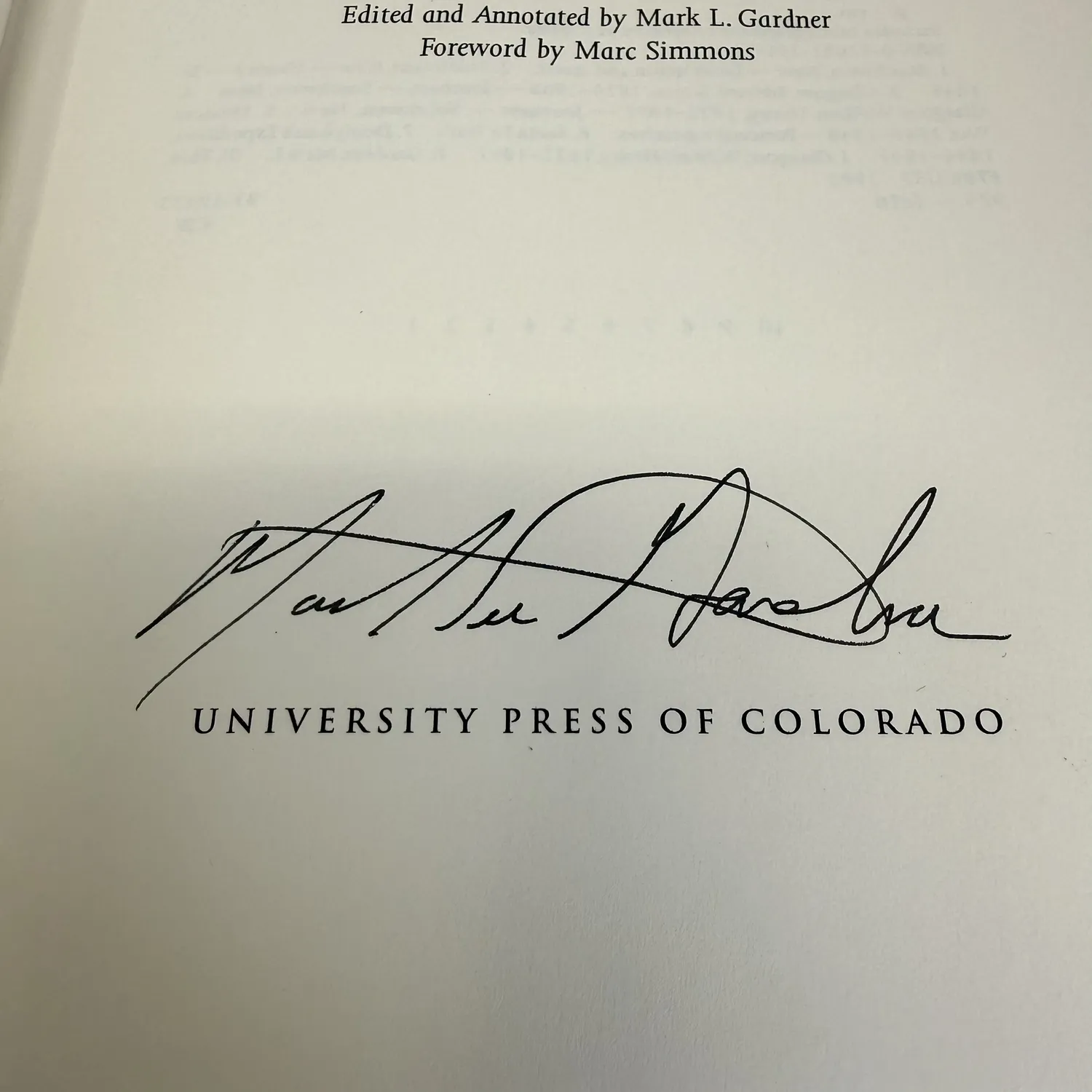 Close-up of Mark L. Gardner signature on title page of Brothers on the Santa Fe and Chihuahua Trails, large flowing script in black ink signed below Edited and Annotated by Mark L. Gardner and Foreword by Marc Simmons credits, above University Press of Colorado imprint, signed first edition 1993, photographed at New Mexico Literacy Project