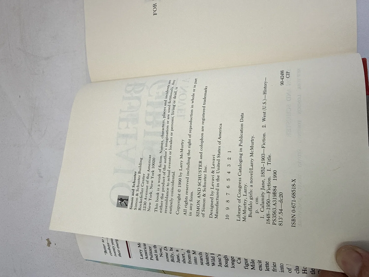 Copyright page of Buffalo Girls first edition showing Simon and Schuster imprint, Copyright 1990 by Larry McMurtry, and complete number line 10 9 8 7 6 5 4 3 2 1 confirming first printing. ISBN 0-671-68518-X. Photographed at the New Mexico Literacy Project sorting desk in Albuquerque.