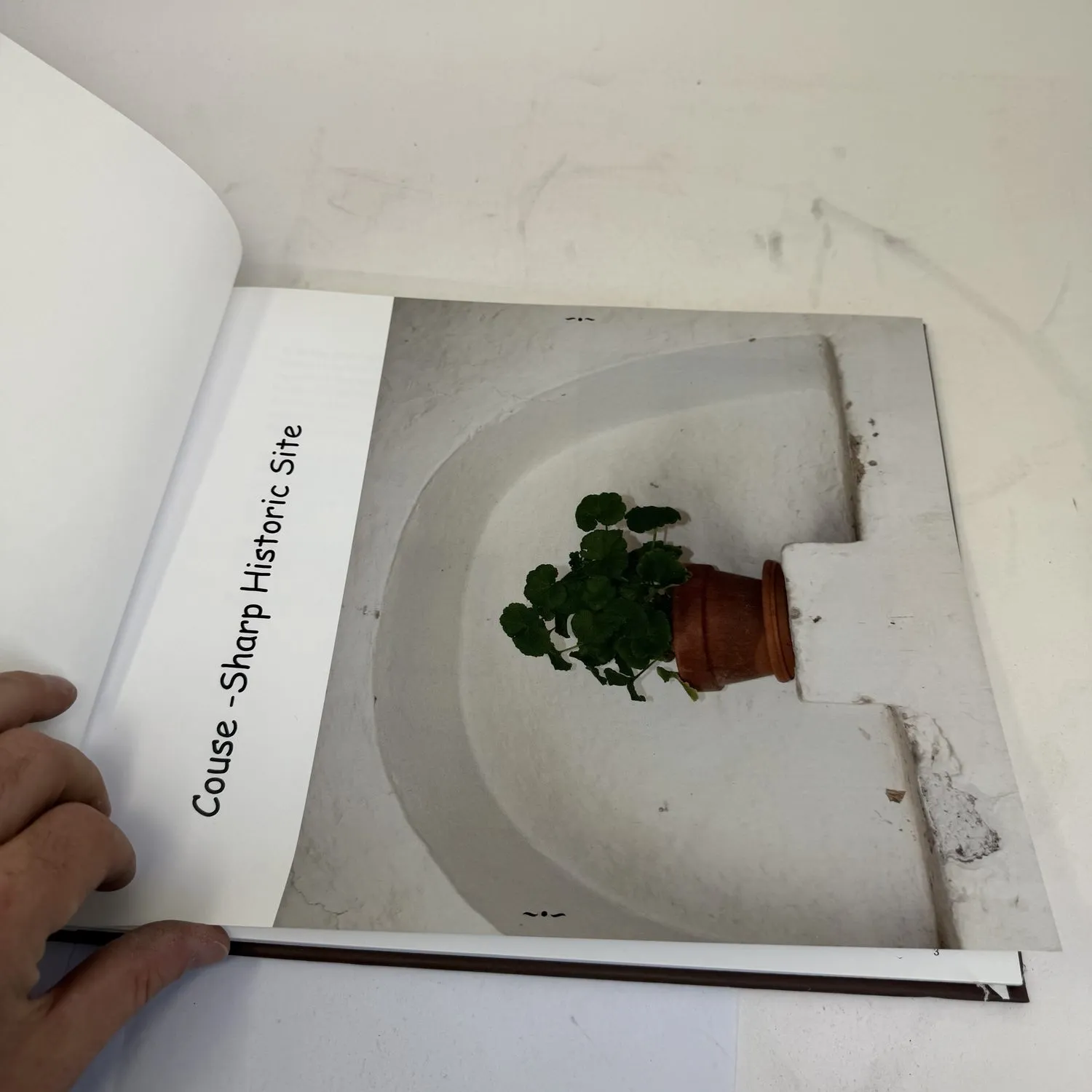 Interior title page of Couse-Sharp Historic Site assessment showing full-page photograph of adobe wall niche with geranium plant and Couse-Sharp Historic Site text — photographed by Josh Eldred at NMLP workspace