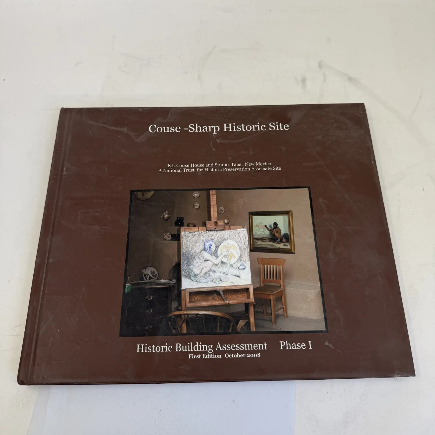 Cover of Couse-Sharp Historic Site: Historic Building Assessment Phase I, First Edition October 2008, showing E.I. Couse studio interior with easel, paintings, and artist materials in Taos New Mexico — photographed by Josh Eldred at the New Mexico Literacy Project workspace