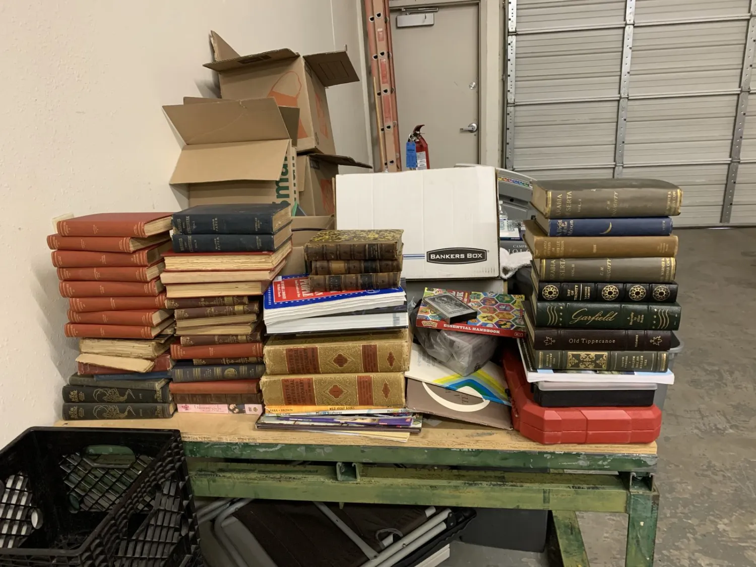 A pile of donated books, photo albums, and personal materials in an estate-cleanout context.