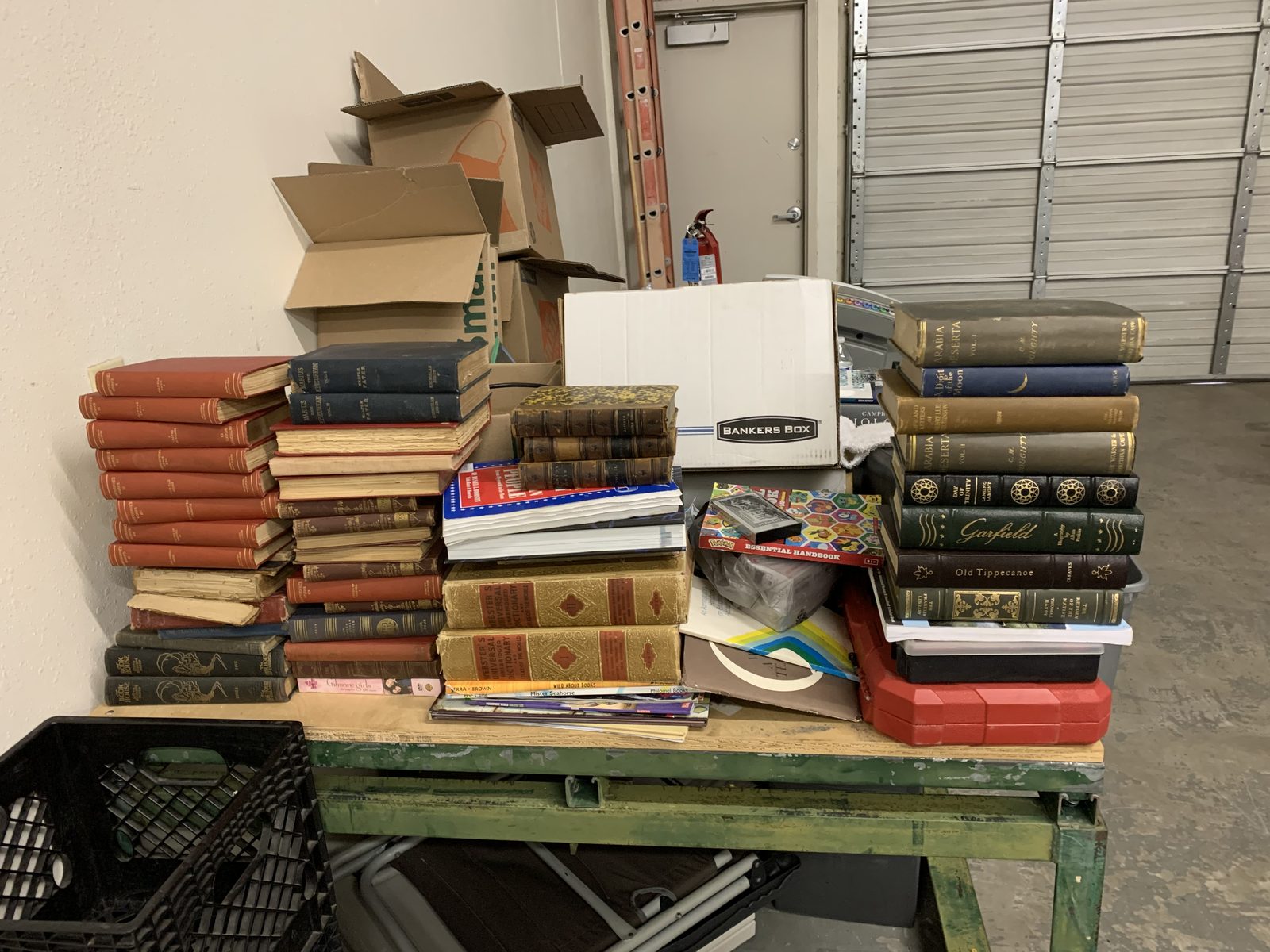 A pile of donated books, photo albums, and personal materials in an estate-cleanout context.