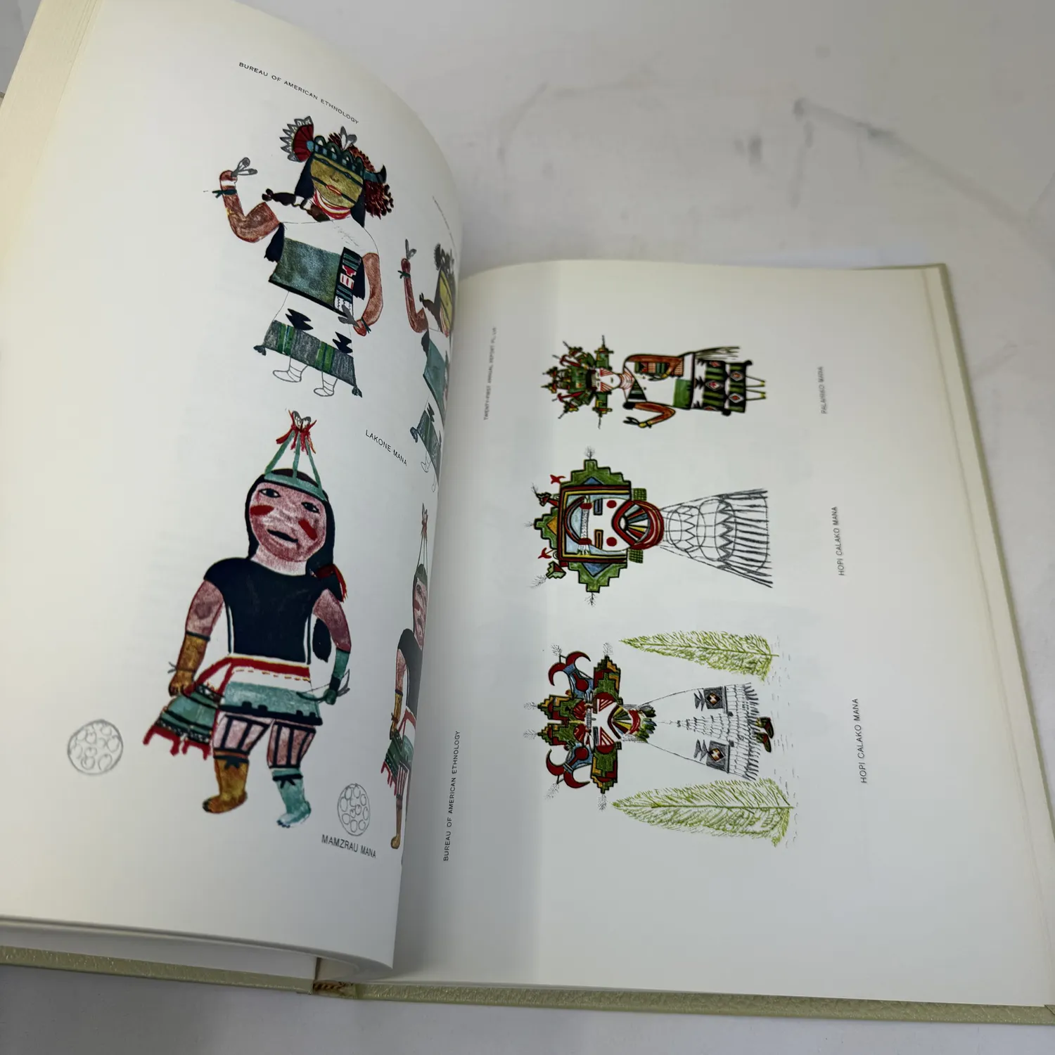 Color plate from Hopi Katcinas by Fewkes showing kachina Mana figures drawn by Native Hopi artists — Lakone Mana with green mask and ceremonial sash, Mamzrau Mana the large figure in black body paint with green headdress, Palahiko Mana, and Hopi Calako Mana with elaborate tableta and feathered costume. Bureau of American Ethnology, public domain 1903