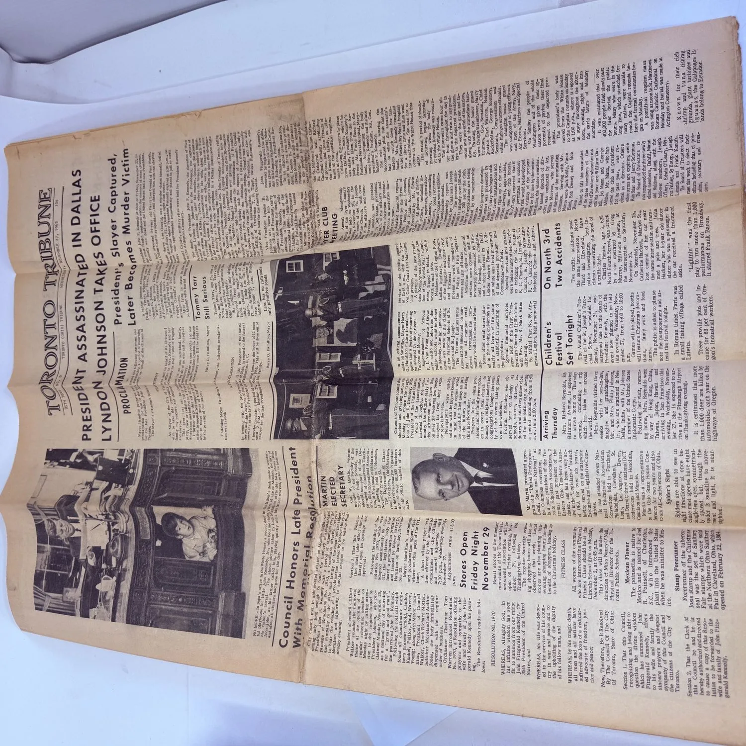 Full vertical shot of the Toronto Tribune front page from November 27 1963, showing the complete layout with JFK assassination headlines, mayor's proclamation, Council Honors Late President memorial resolution, photographs, and local news stories. Yellowed newsprint with original fold creases.