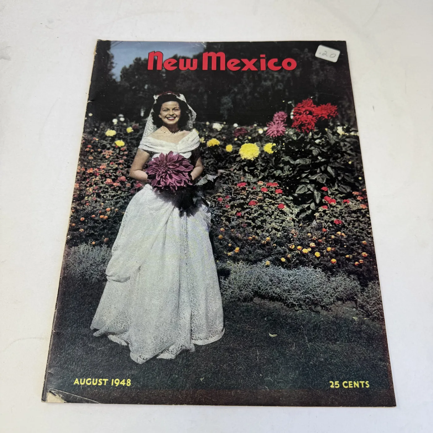 New Mexico Magazine August 1948 cover: bride in a white gown holding flowers in a dahlia garden — photographed at New Mexico Literacy Project