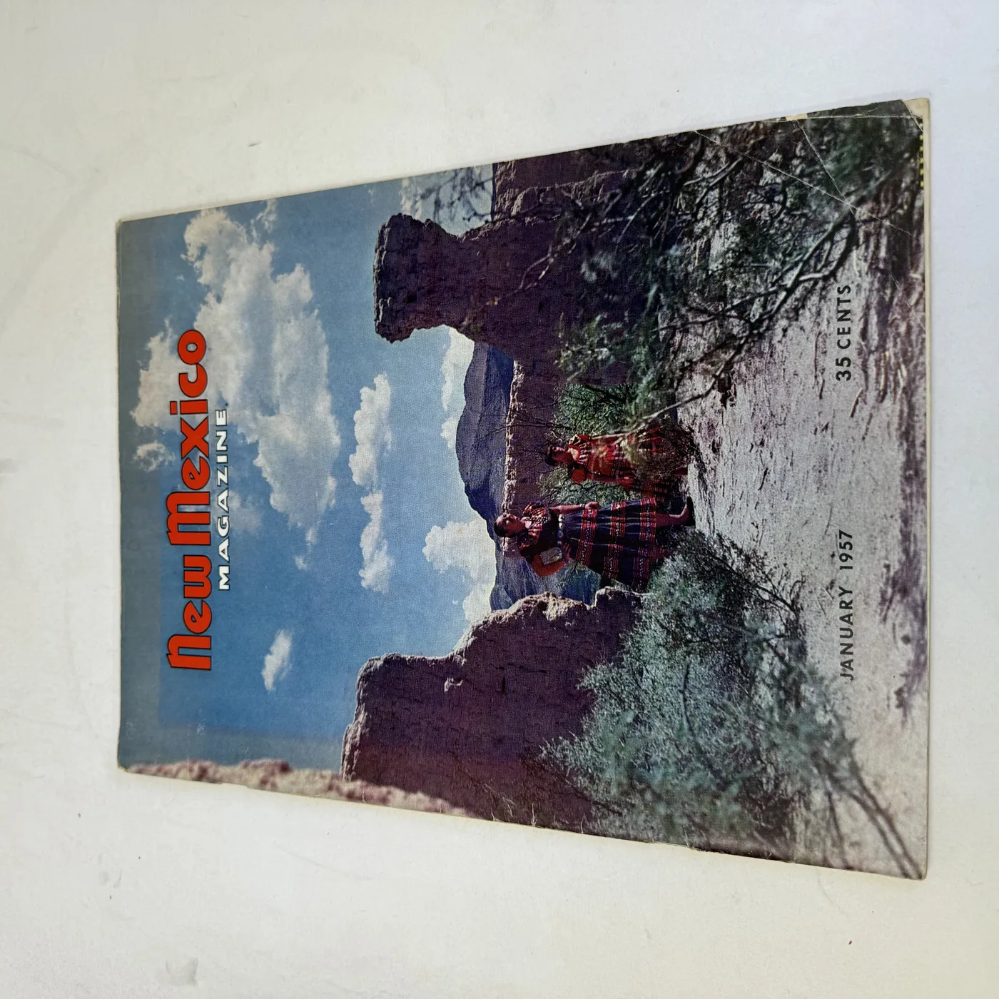 New Mexico Magazine January 1957 cover: adobe mission ruins under a summer sky with two women in traditional dress, thirty-five cents — photographed at New Mexico Literacy Project