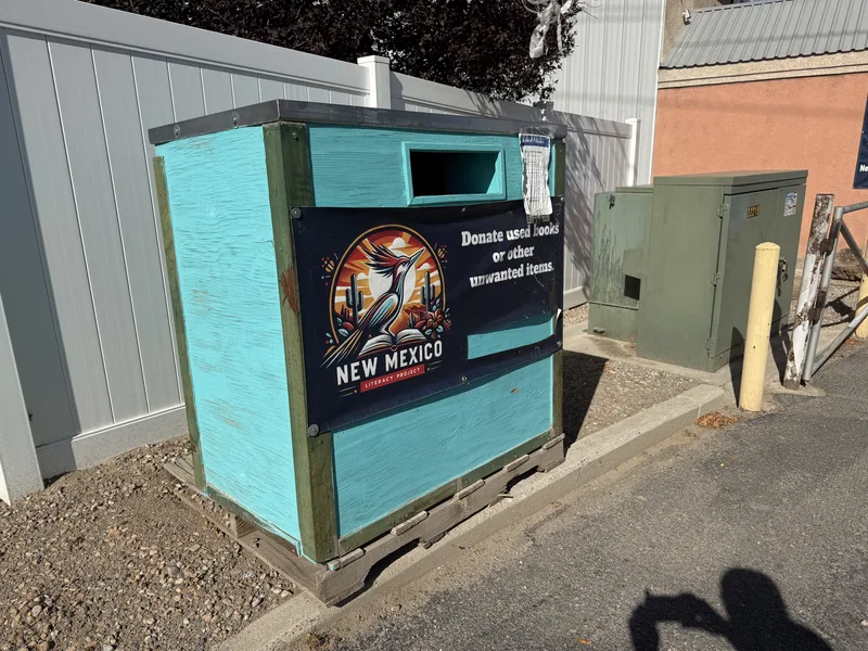 The turquoise drop box with the roadrunner panel, outside the gate by the road at 5445 Edith Blvd NE