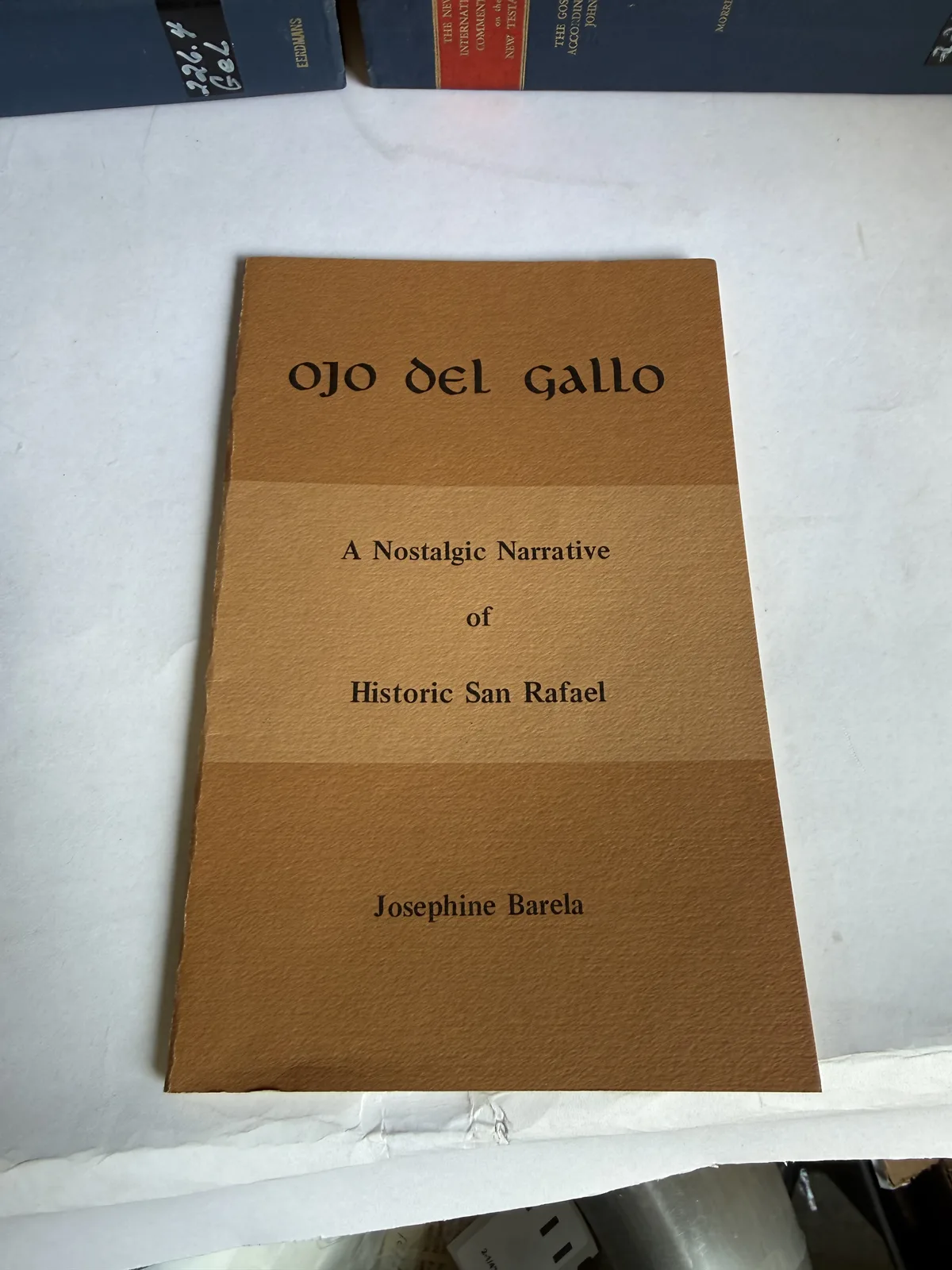 Plain brown printed wrapper of Ojo del Gallo, a nostalgic narrative of historic San Rafael New Mexico by Josephine Barela, photographed at New Mexico Literacy Project