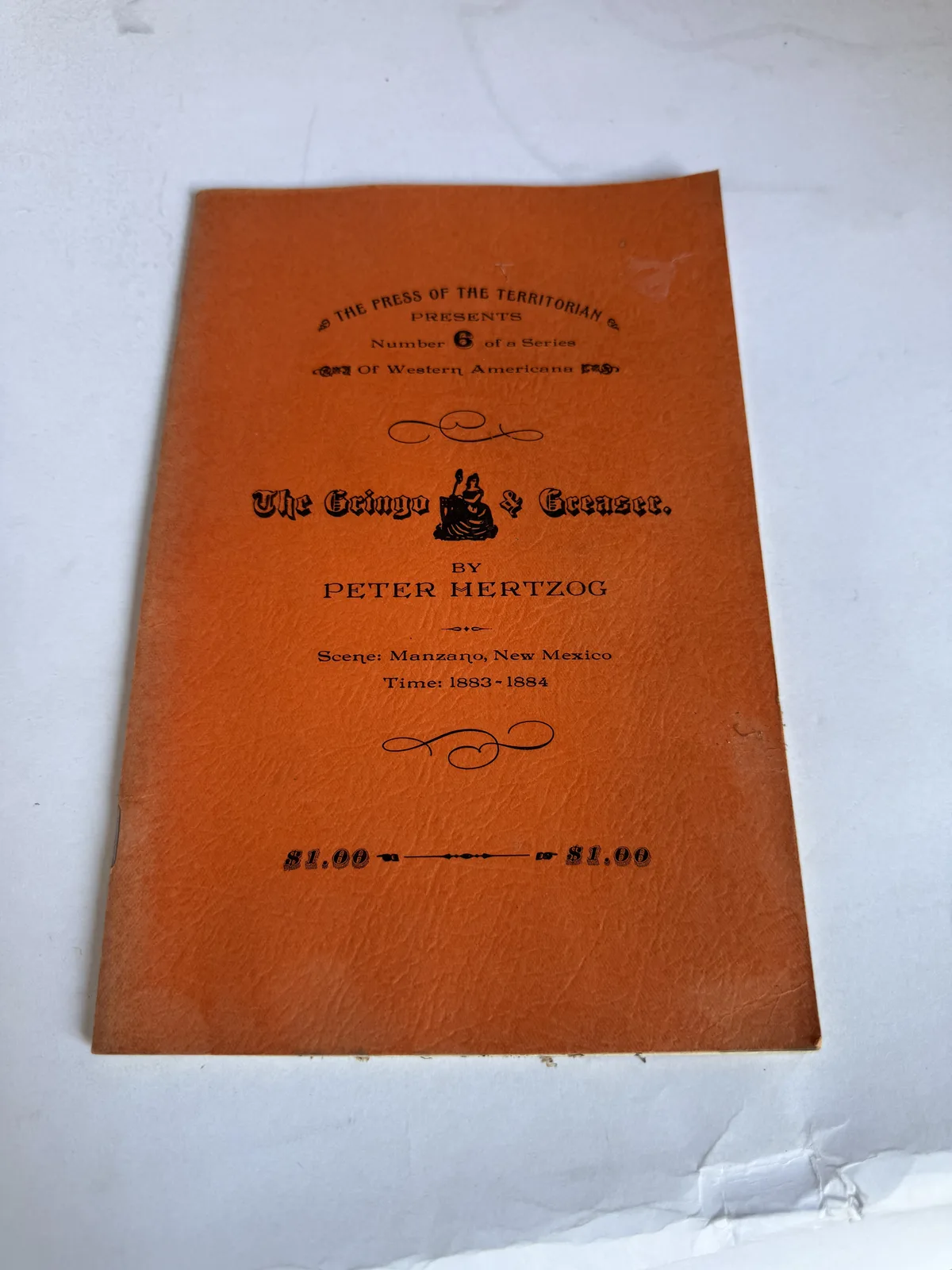 Orange printed wrapper of a Press of the Territorian pamphlet by Peter Hertzog, Santa Fe, on Socorro and Magdalena New Mexico territorial newspapers, photographed at New Mexico Literacy Project
