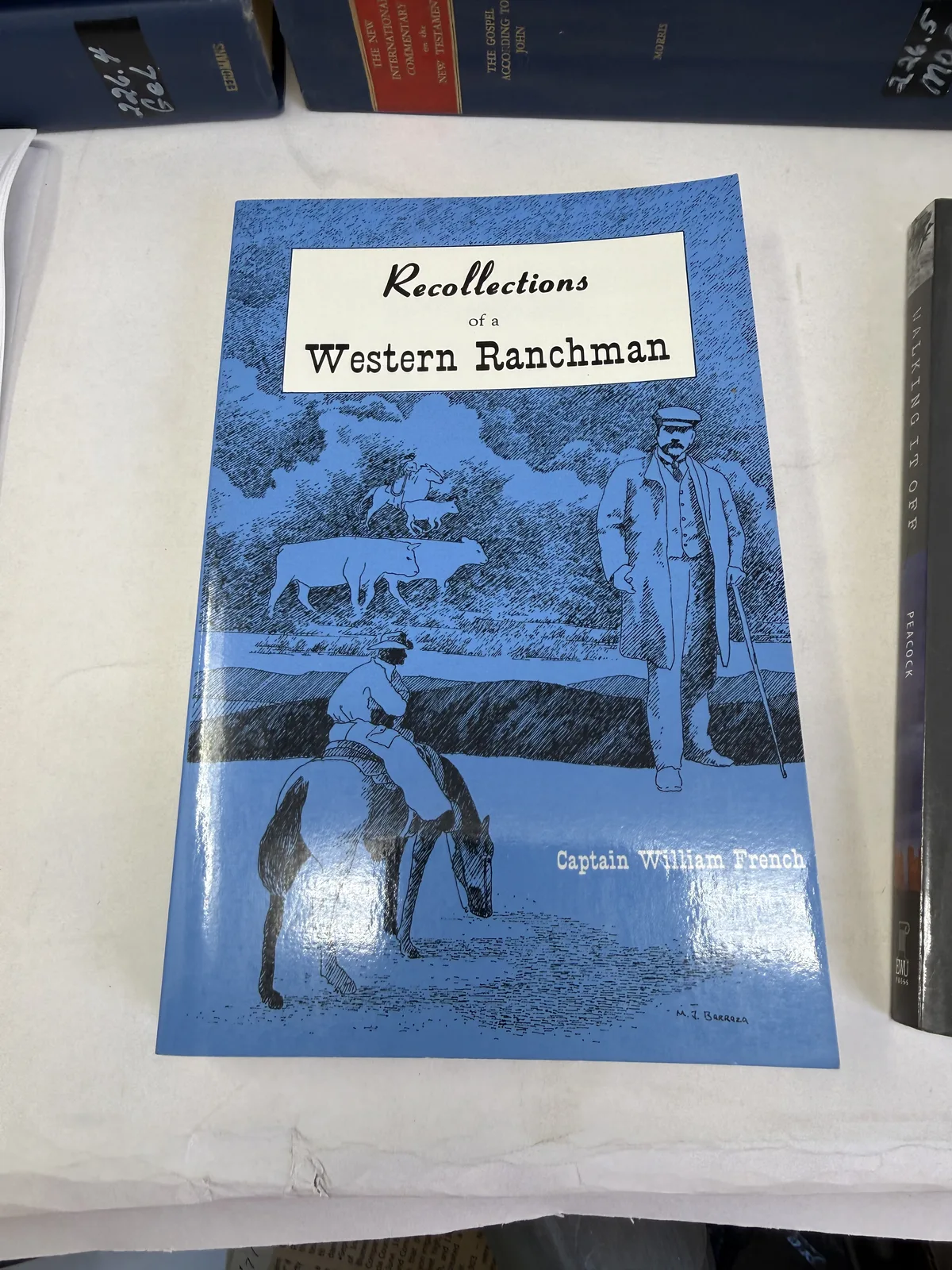 Blue cover of Recollections of a Western Ranchman by Captain William French, High-Lonesome Books, showing a line drawing of cattle, photographed at New Mexico Literacy Project