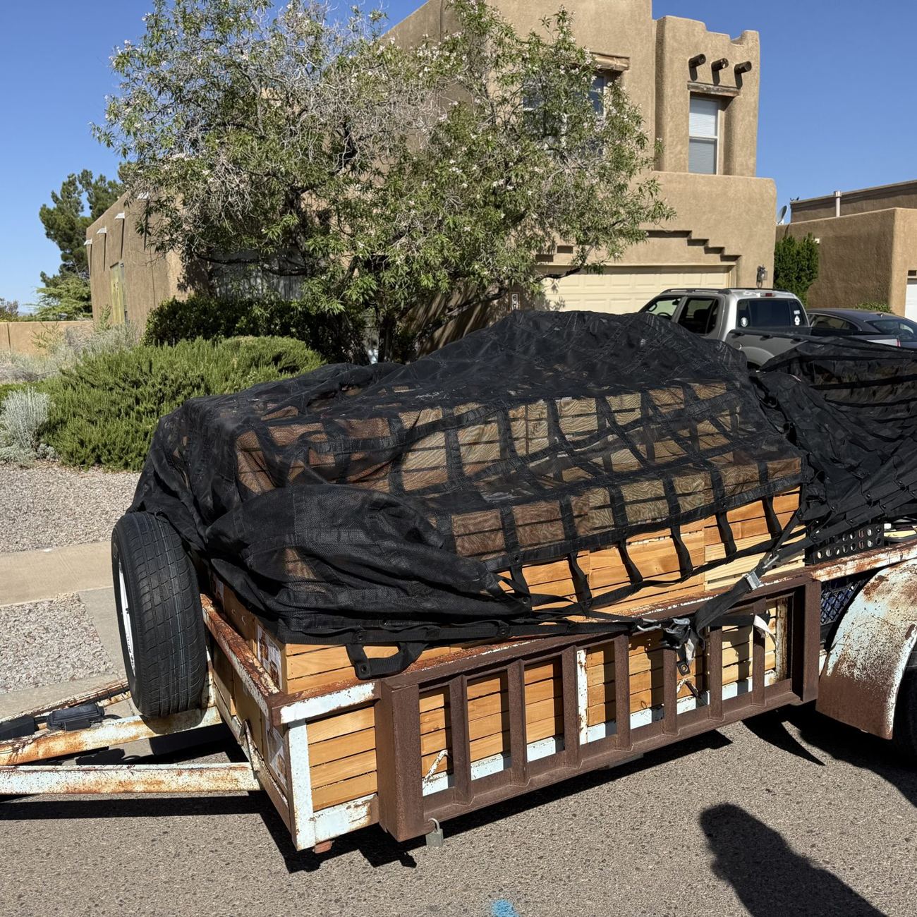 A trailer of crated books from an Albuquerque estate library, netted and secured for the drive back to the warehouse