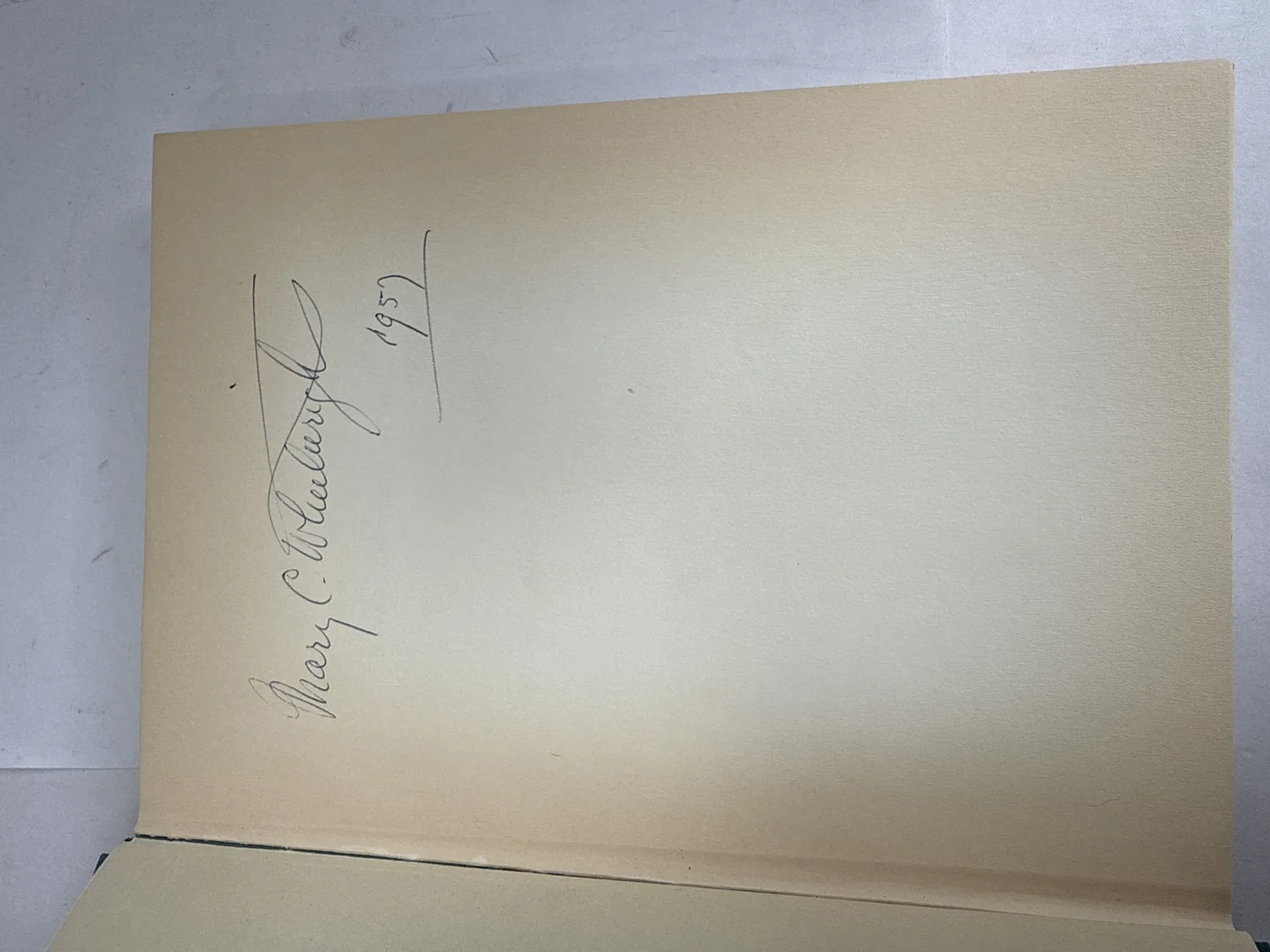 Mary C. Wheelwright 1957 signature in pencil on the front free endpaper of Navajo Creation Myth, large confident script by the founder of the Museum of Navajo Ceremonial Art. Photographed at the New Mexico Literacy Project sorting desk in Albuquerque.