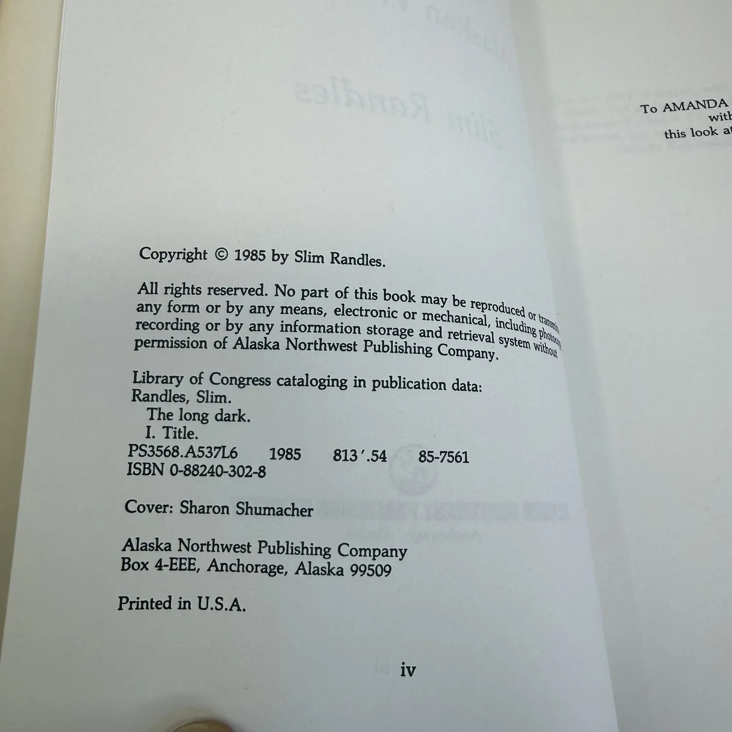 Copyright page of The Long Dark by Slim Randles showing Copyright 1985 by Slim Randles, Library of Congress PS3568.A537L6 1985 813 point 54 85-7561, ISBN 0-88240-302-8, Cover Sharon Shumacher, Alaska Northwest Publishing Company Box 4-EEE Anchorage Alaska 99509, Printed in U.S.A. Dedication to Amanda visible on facing page.