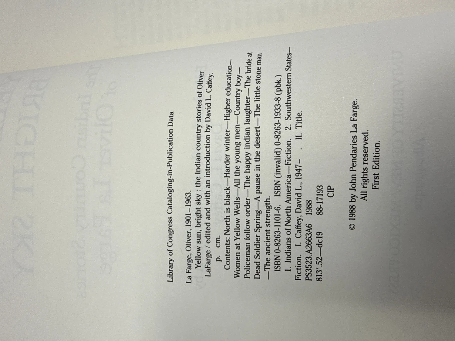 Copyright page of Yellow Sun, Bright Sky — Library of Congress CIP data showing La Farge, Oliver, 1901-1963, contents listing twelve Indian Country stories, ISBN 0-8263-1101-6 and 0-8263-1933-8 paperback, copyright 1988 by John Pendaries La Farge, First Edition. Photographed at the New Mexico Literacy Project sorting desk in Albuquerque.