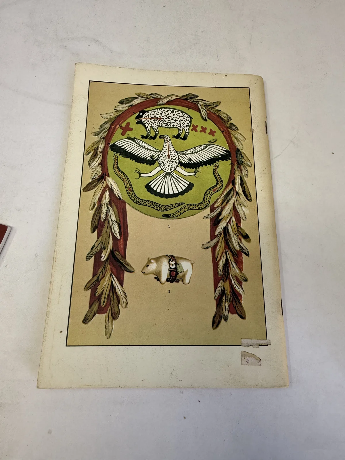 Color plate of Zuni fetishes and a feathered prayer offering reproduced from Cushing's Bureau of Ethnology report, photographed at New Mexico Literacy Project